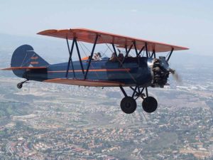 Travel agents Kerry Sullivan and Alison Bird wave from their biplane over San Diego