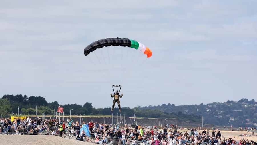Member of the defense forces parachutes to the beach during Bray air display