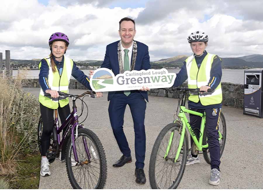 Scoil Naomh Bríd, Omeath students, Mary Rose O'Sullivan and Ciara Keaveney, with ClIr Seán Kelly, Cathaoirleach of Louth County Council at the Carlingford Lough Greenway celebration event.