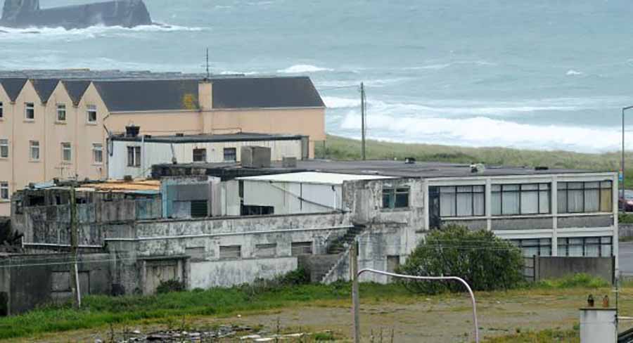 The derlinct hotel overlooks Owenahincha Beach